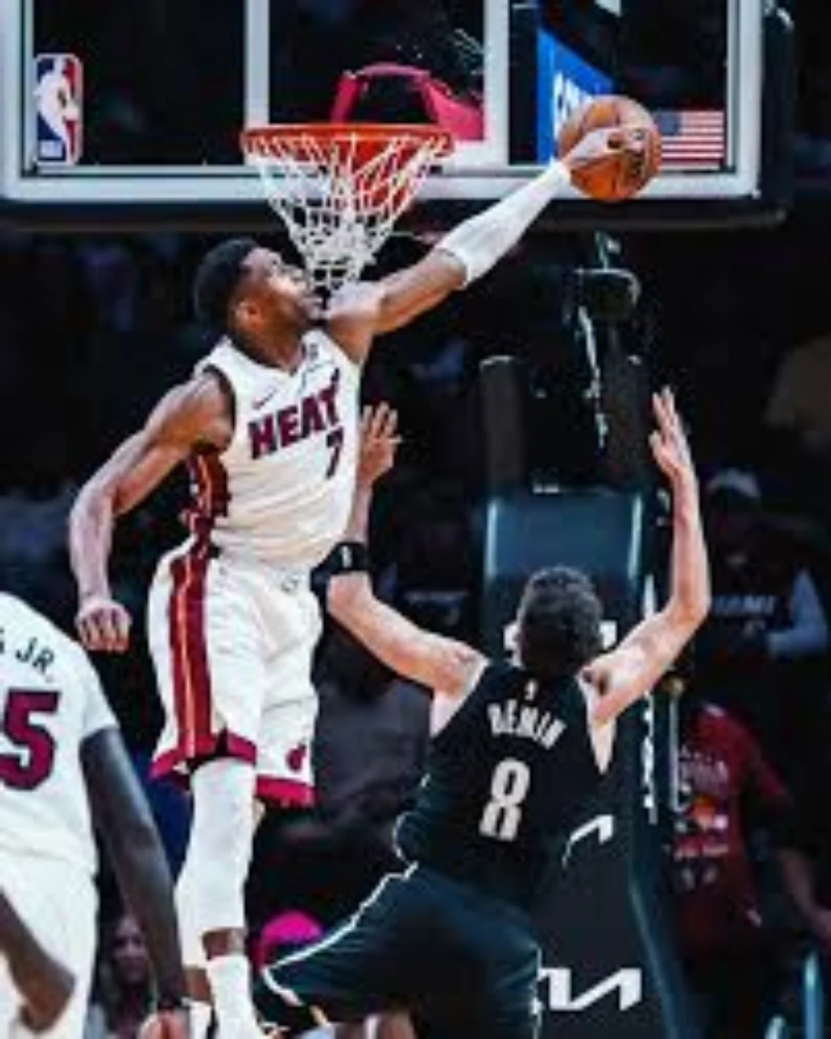 Giannis Antetokounmpo in a white Miami Heat uniform dunking at the rim