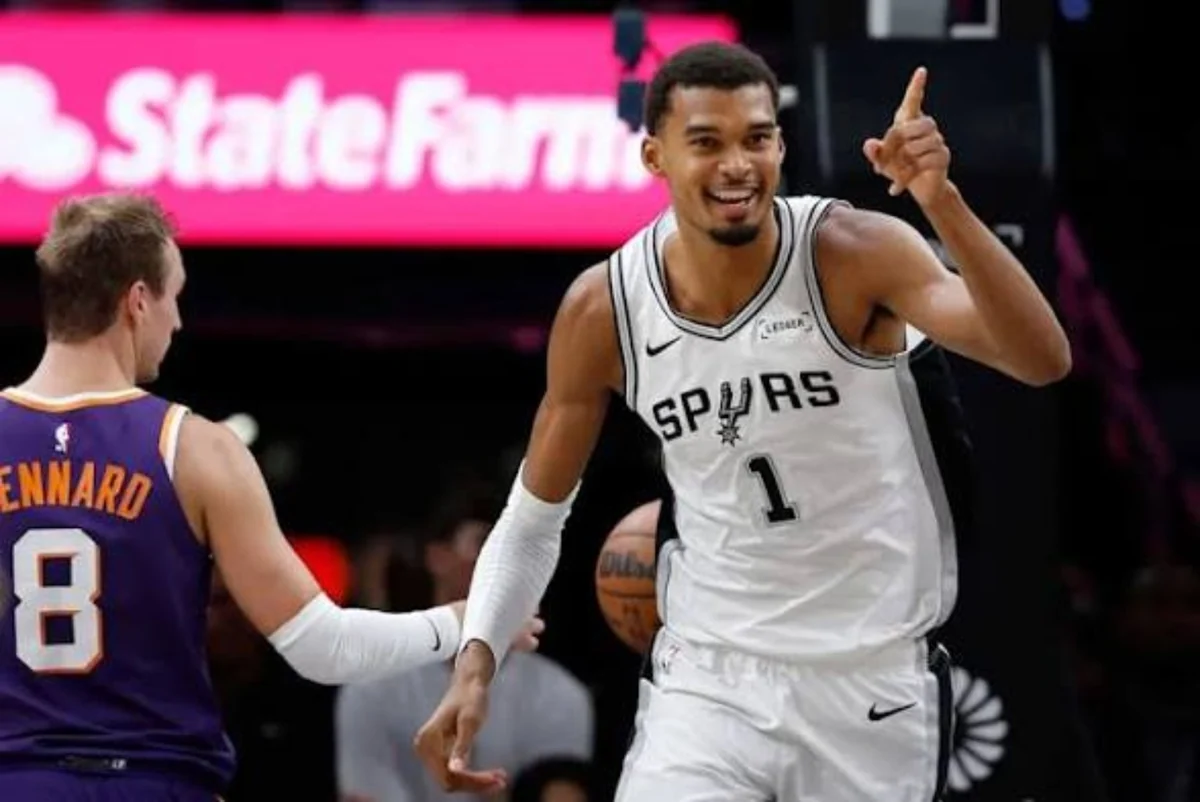 Victor Wembanyama in a white San Antonio Spurs uniform celebrating on the court