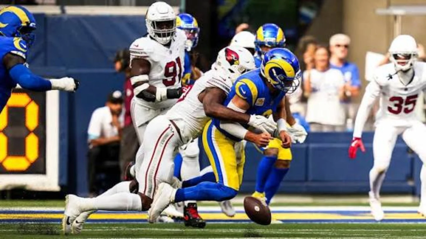 Rams and Cardinals players collide during a football play
