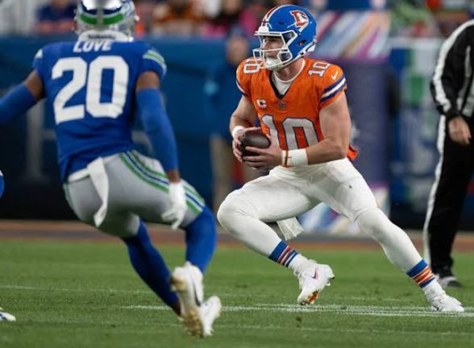 Denver quarterback Bo Nix carrying the football against Seattle