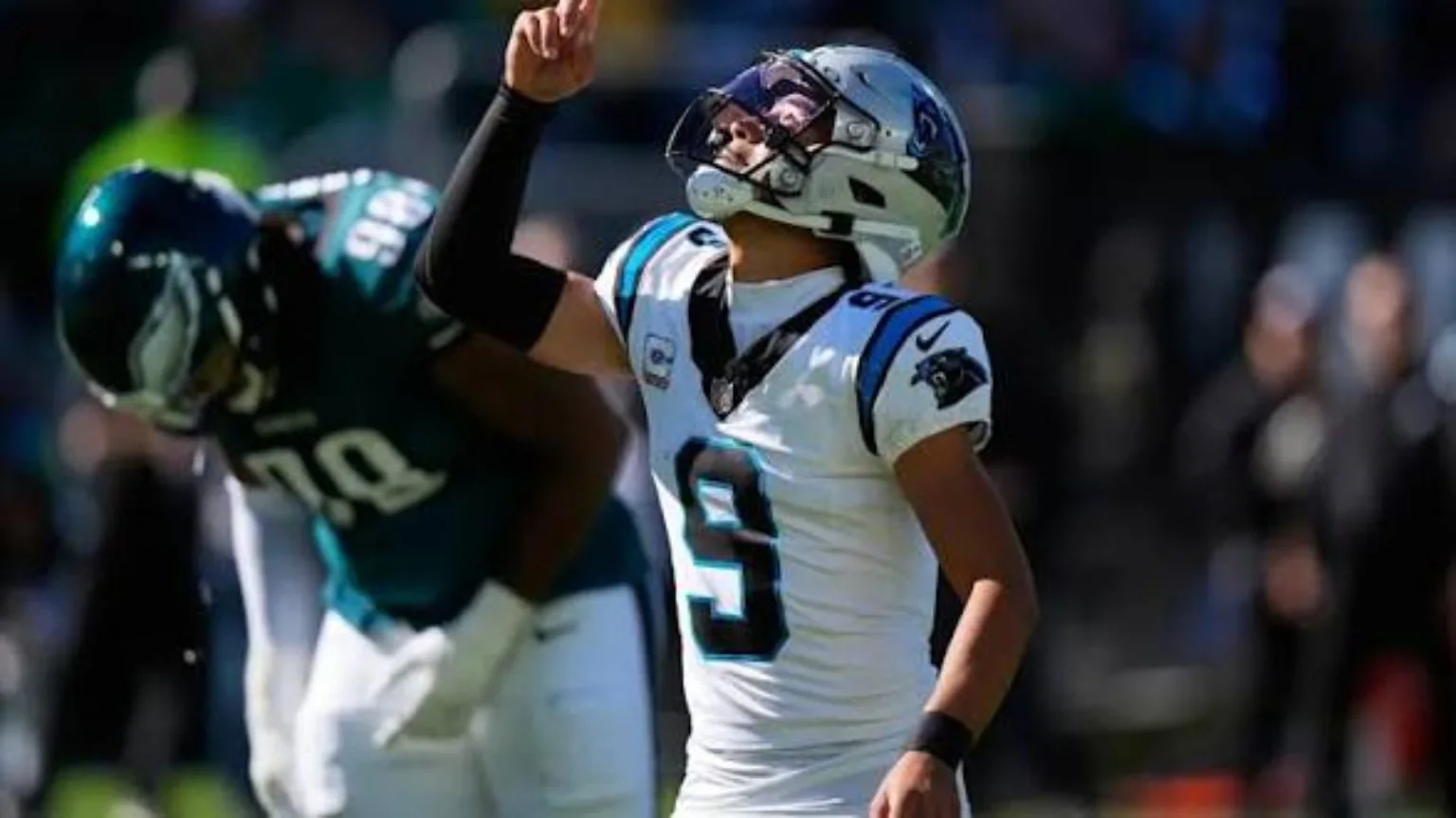 Carolina Panthers quarterback on the football field with Philadelphia Eagles player nearby