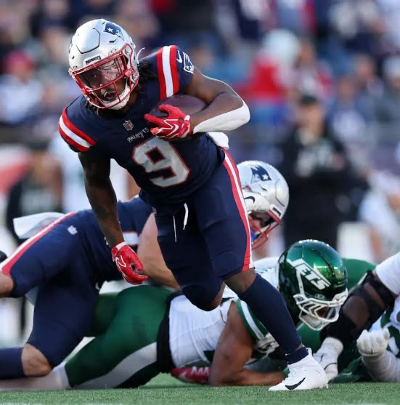 New England Patriots player carrying the ball against the New York Jets