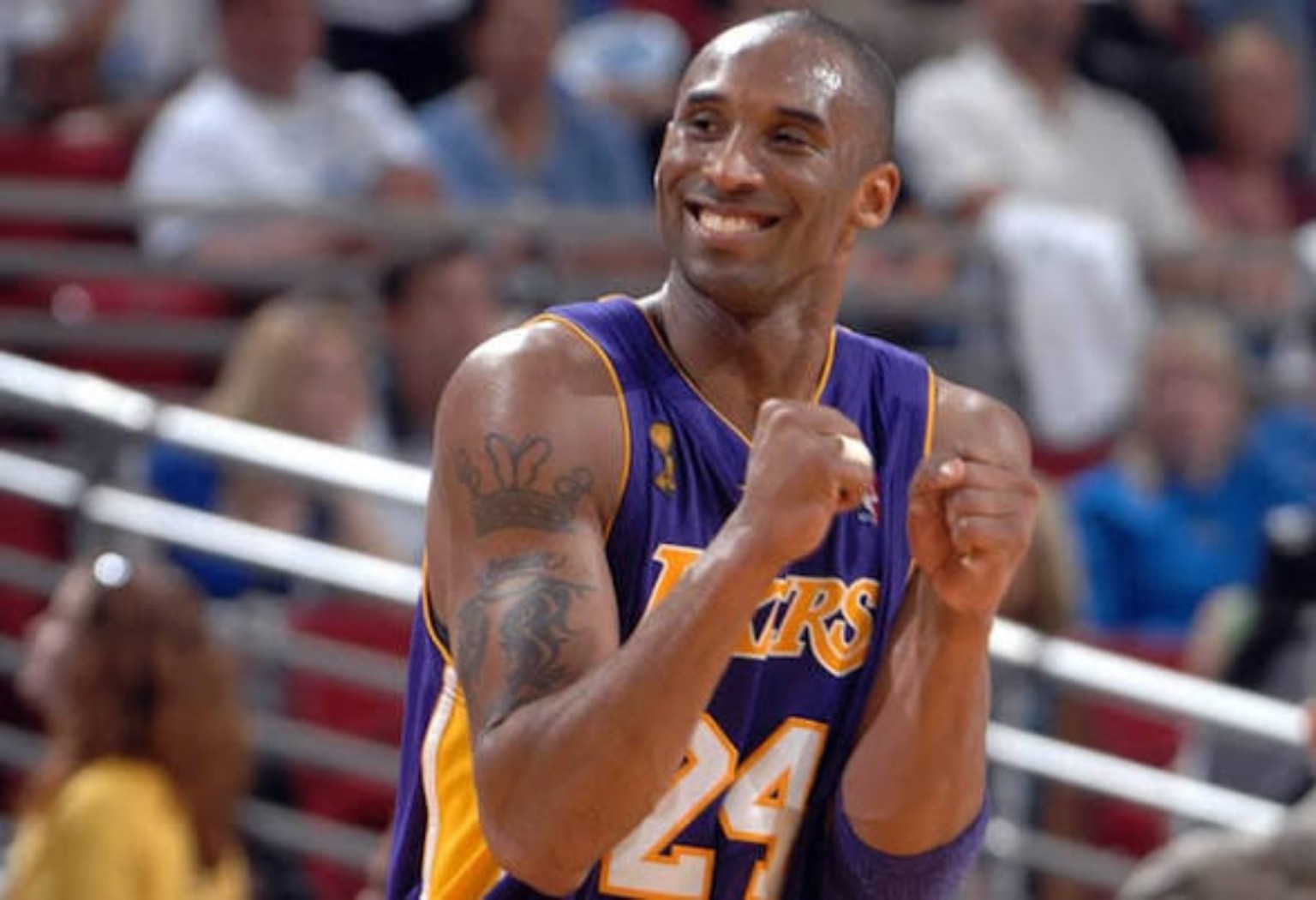 Kobe Bryant smiling in a purple Lakers number 24 uniform