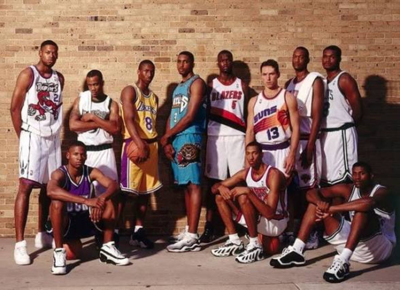 Members of the 1996 NBA rookie class posing together in team uniforms